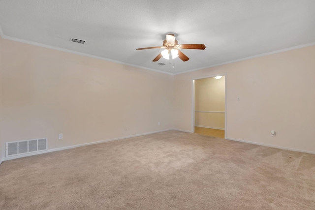 carpeted spare room with ceiling fan and ornamental molding