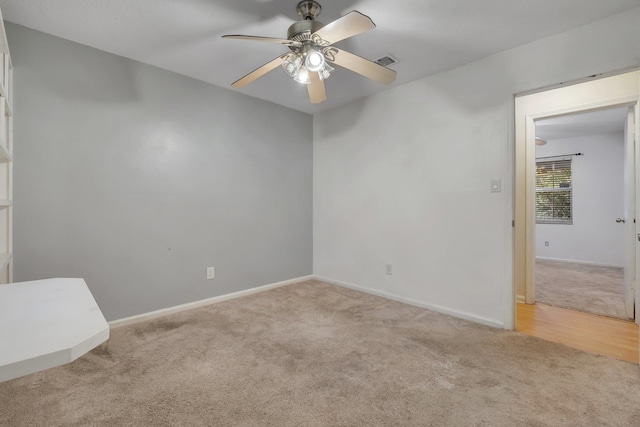 spare room with ceiling fan and light colored carpet