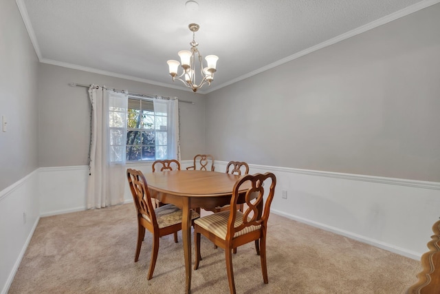 dining space with light carpet, ornamental molding, a textured ceiling, and an inviting chandelier