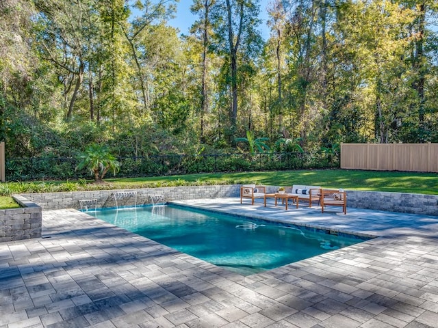 view of pool with pool water feature, an outdoor living space, a patio area, and a lawn