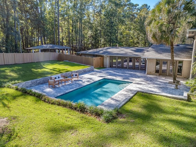 view of pool with a lawn, french doors, and a patio