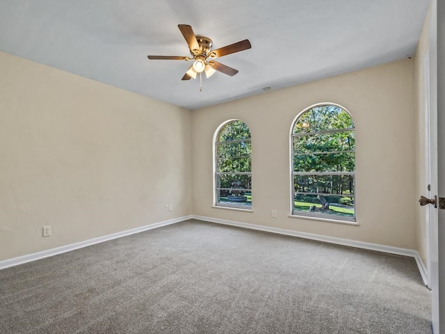 carpeted spare room featuring ceiling fan