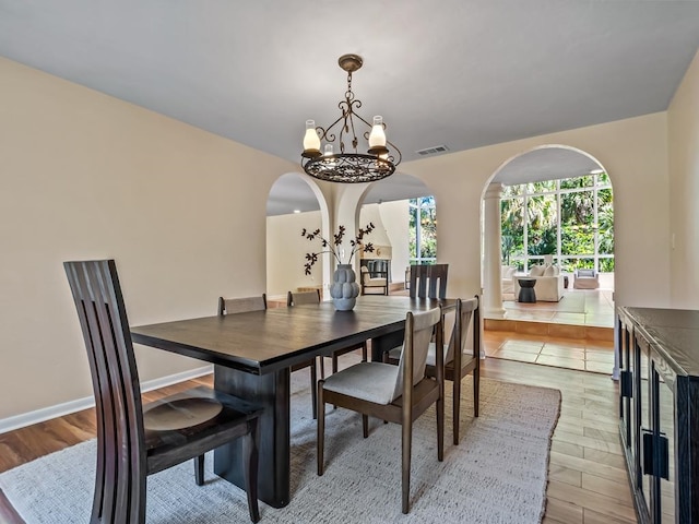 dining room with light wood-type flooring and a chandelier