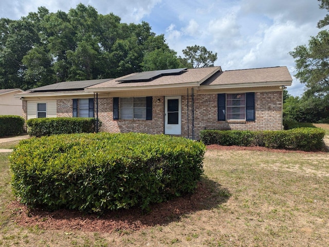 1106 Woodland Dr, Tallahassee, FL 32305 - ranch-style home featuring solar panels, a front yard, and brick siding