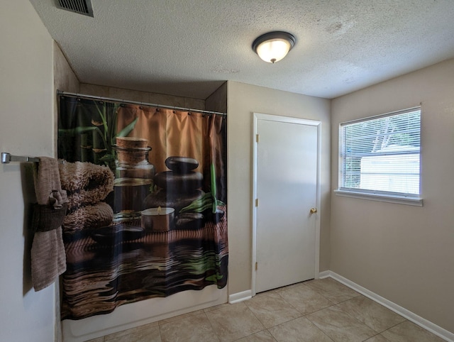 1106 Woodland Dr, Tallahassee, FL 32305 - foyer entrance featuring tile patterned floors, visible vents, a textured ceiling, and baseboards