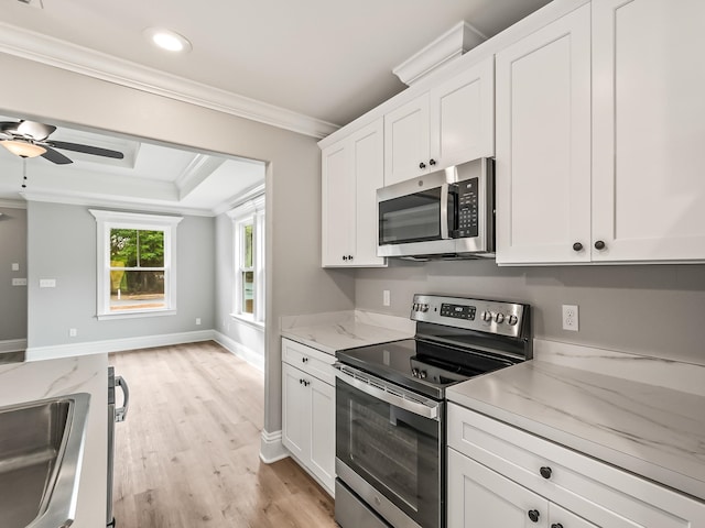 kitchen featuring white cabinets, light stone countertops, ornamental molding, and stainless steel appliances