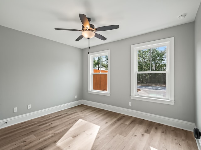 spare room featuring ceiling fan, plenty of natural light, and light wood-type flooring