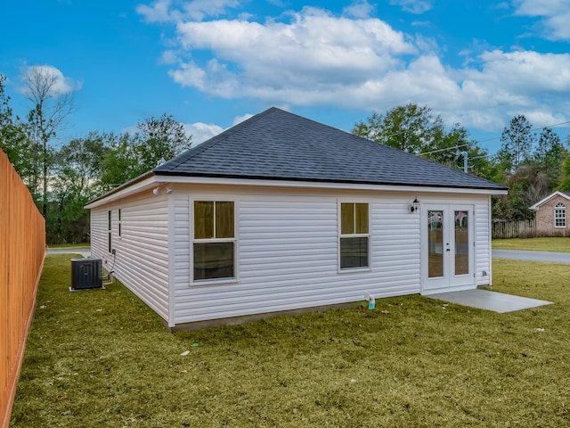 back of property featuring a lawn, cooling unit, and french doors