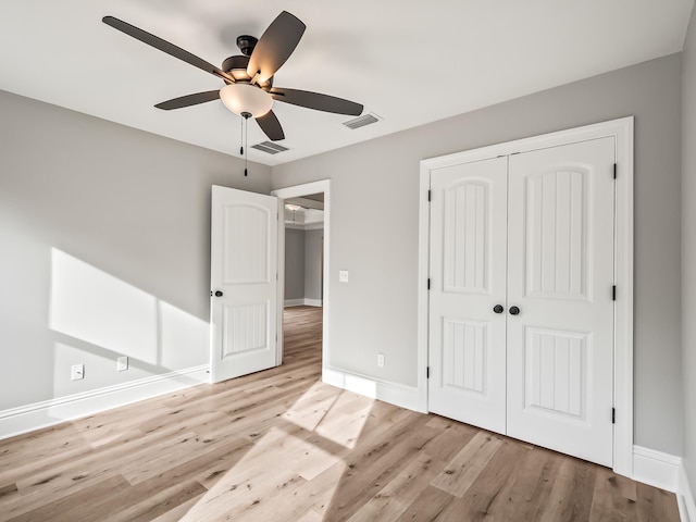 unfurnished bedroom featuring a closet, light hardwood / wood-style flooring, and ceiling fan