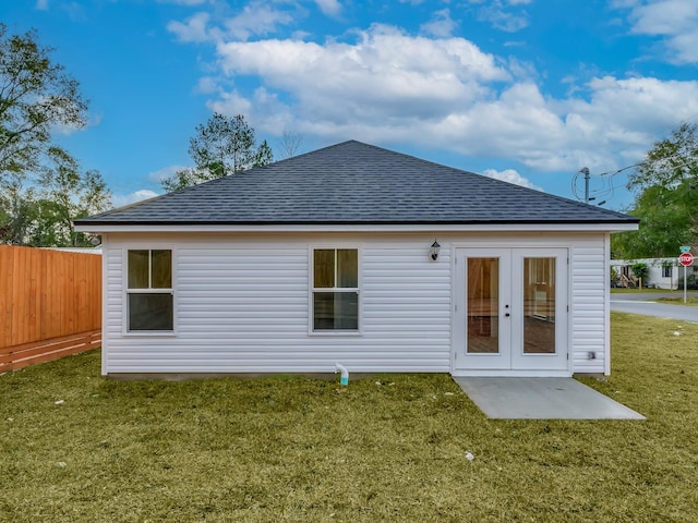 back of property with a lawn and french doors