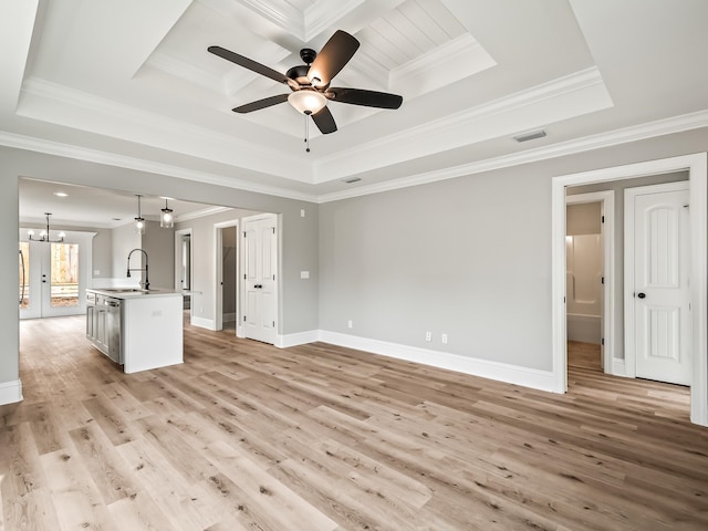 unfurnished living room with a tray ceiling, crown molding, and light hardwood / wood-style flooring