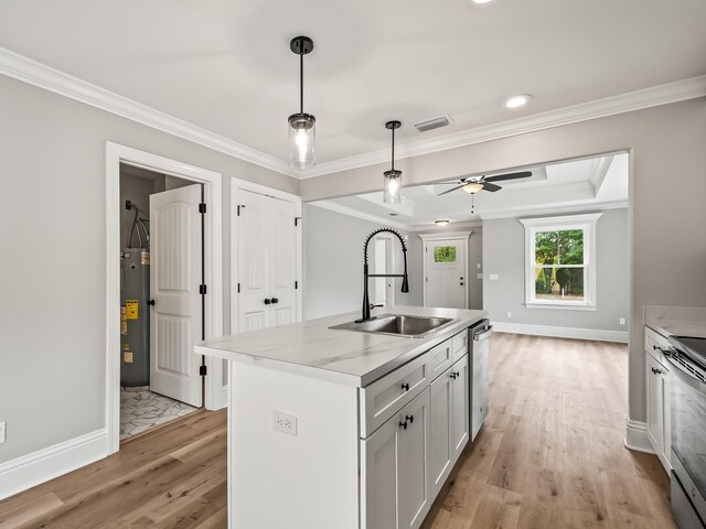 kitchen featuring appliances with stainless steel finishes, sink, a center island with sink, light hardwood / wood-style flooring, and white cabinets