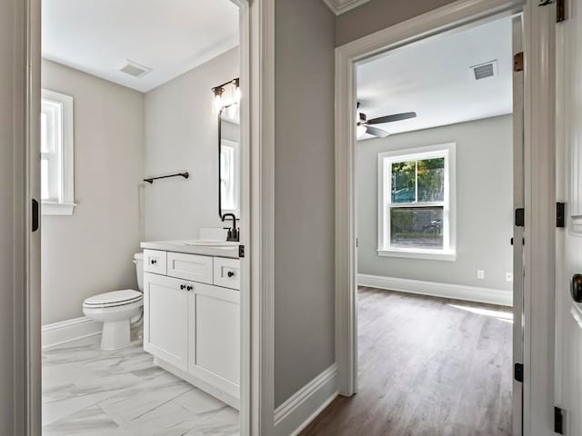 bathroom featuring hardwood / wood-style flooring, vanity, ceiling fan, and toilet