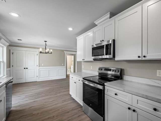 kitchen with white cabinetry, crown molding, a notable chandelier, and appliances with stainless steel finishes