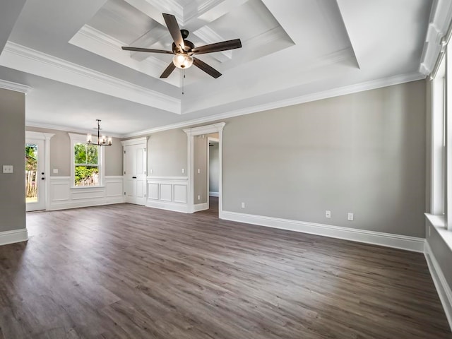 unfurnished living room featuring a tray ceiling, ceiling fan with notable chandelier, dark hardwood / wood-style floors, and ornamental molding