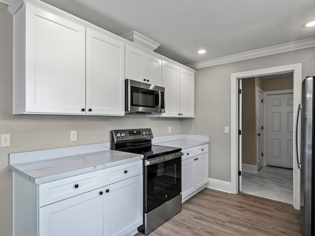 kitchen featuring light stone countertops, stainless steel appliances, crown molding, white cabinets, and light wood-type flooring