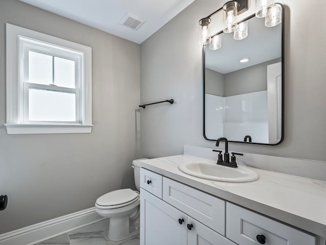 bathroom featuring vanity, toilet, and walk in shower