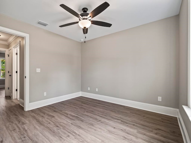 unfurnished room featuring crown molding, ceiling fan, and dark hardwood / wood-style floors