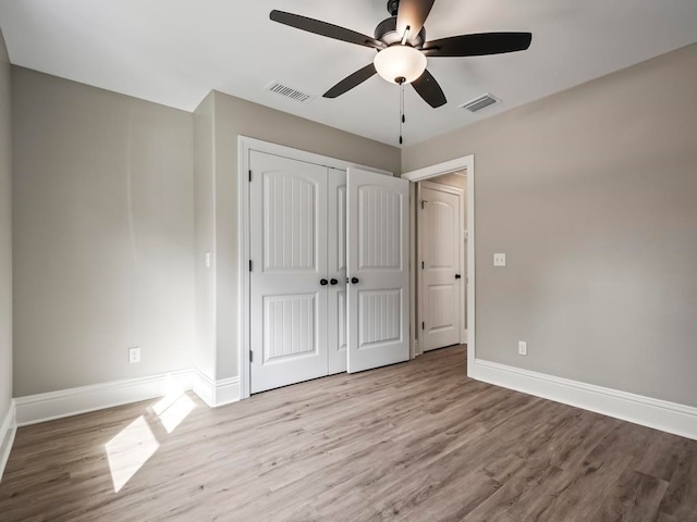 unfurnished bedroom featuring ceiling fan, light wood-type flooring, and a closet