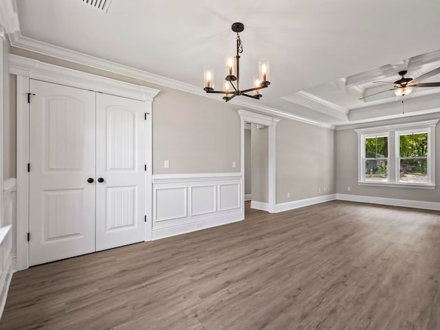 interior space featuring a tray ceiling, ceiling fan with notable chandelier, dark hardwood / wood-style floors, and ornamental molding