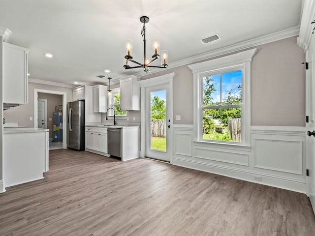 kitchen featuring white cabinets, a wealth of natural light, light wood-type flooring, and appliances with stainless steel finishes