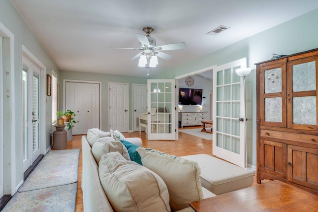 living room featuring french doors and ceiling fan