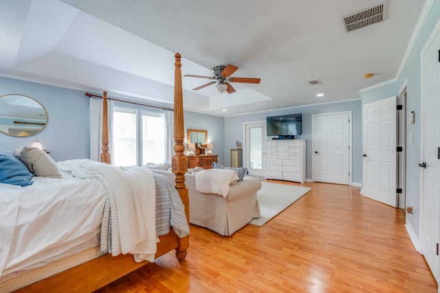 bedroom featuring light hardwood / wood-style floors, a raised ceiling, ceiling fan, and crown molding