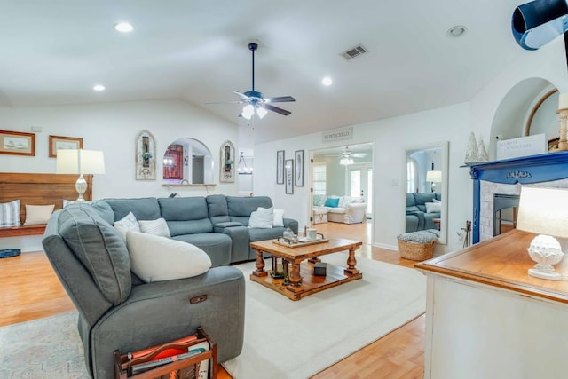 living room with light wood-type flooring, lofted ceiling, and ceiling fan