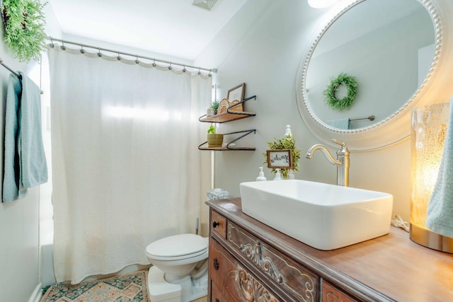 full bathroom with shower / tub combo with curtain, vanity, and toilet