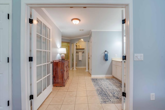 corridor featuring light tile patterned floors and crown molding