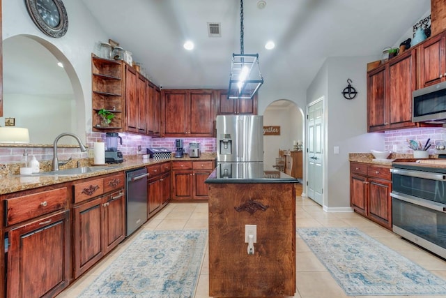 kitchen with stainless steel appliances, sink, tasteful backsplash, lofted ceiling, and a kitchen island