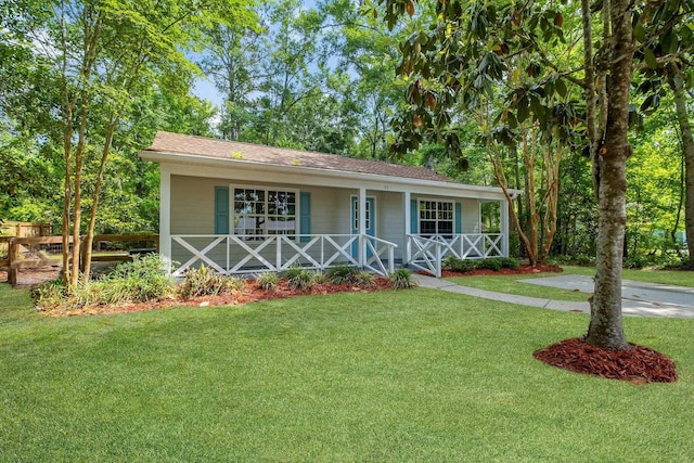 32 Pirates Cove Ln, Saint Marks, FL 32355 - view of front facade featuring covered porch, a front yard, and roof with shingles