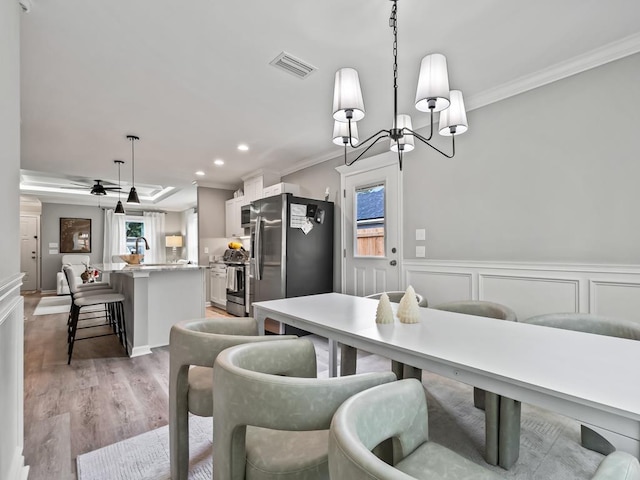 dining space featuring ornamental molding, a healthy amount of sunlight, and light wood-type flooring