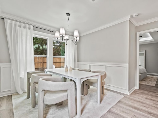 dining room featuring a chandelier, crown molding, and light hardwood / wood-style floors