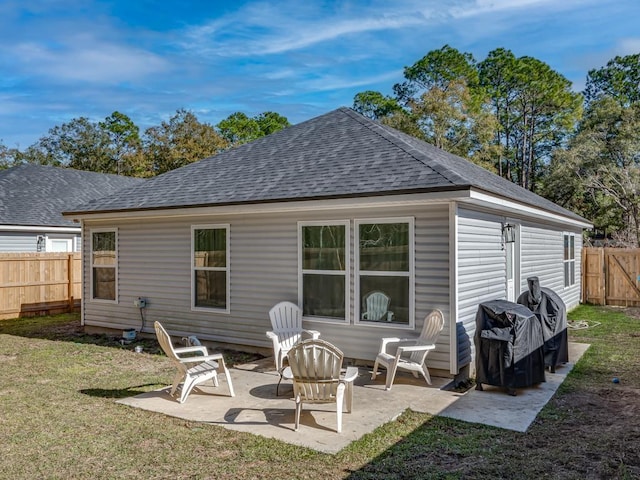 back of property with a lawn and a patio