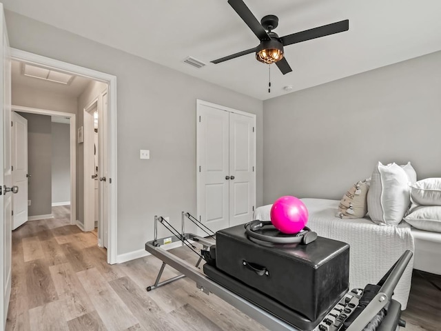 exercise area with ceiling fan and light hardwood / wood-style flooring