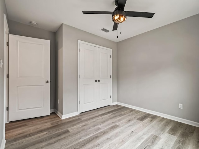 unfurnished bedroom with ceiling fan, light hardwood / wood-style floors, and a closet