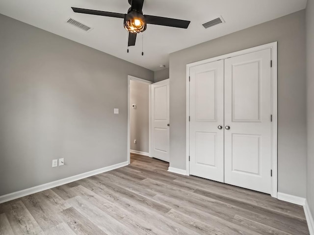 unfurnished bedroom featuring ceiling fan, light hardwood / wood-style flooring, and a closet