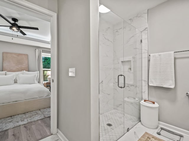 bathroom with hardwood / wood-style floors, a shower with door, and ceiling fan