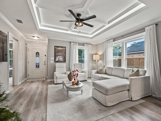 living room with ceiling fan, a raised ceiling, ornamental molding, and light hardwood / wood-style flooring