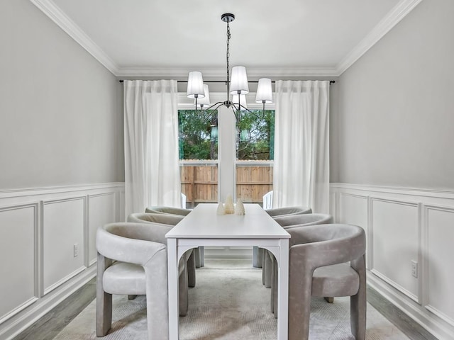 dining room with crown molding, hardwood / wood-style floors, and an inviting chandelier