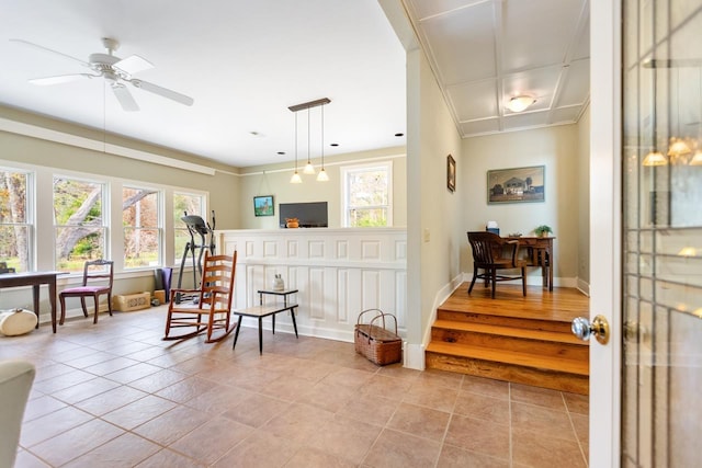 living area featuring light tile patterned floors, a wealth of natural light, and ceiling fan