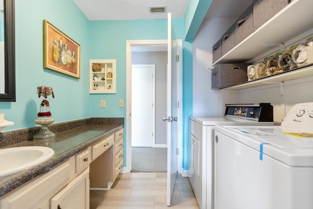 laundry area featuring sink, light tile patterned floors, and washer and clothes dryer