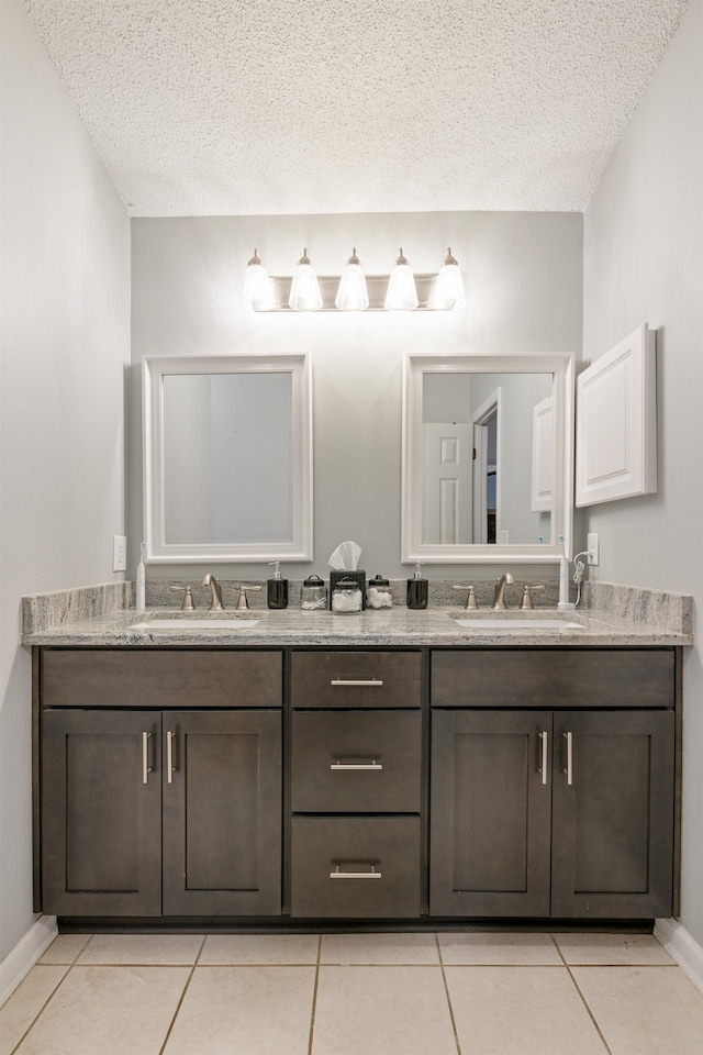 bathroom with a textured ceiling, tile patterned floors, and vanity