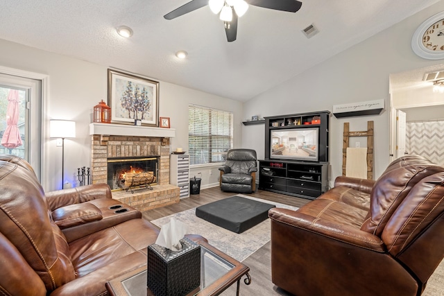 living room with hardwood / wood-style flooring, a brick fireplace, plenty of natural light, and lofted ceiling