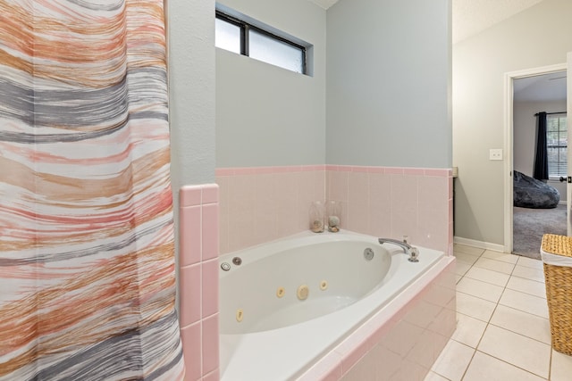 bathroom featuring tiled bath, vaulted ceiling, and tile patterned flooring