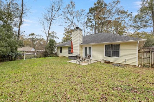 back of property with a lawn and a patio