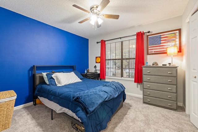 bedroom featuring light carpet, ceiling fan, and a textured ceiling