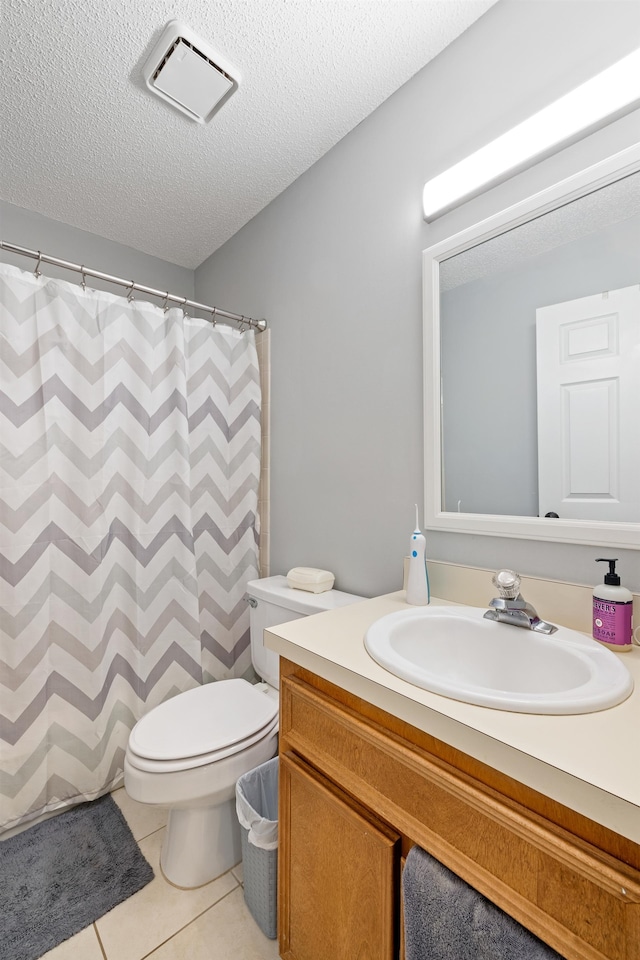 bathroom featuring toilet, a textured ceiling, curtained shower, tile patterned floors, and vanity