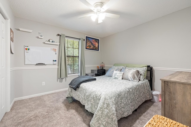 bedroom with ceiling fan, carpet, and a textured ceiling